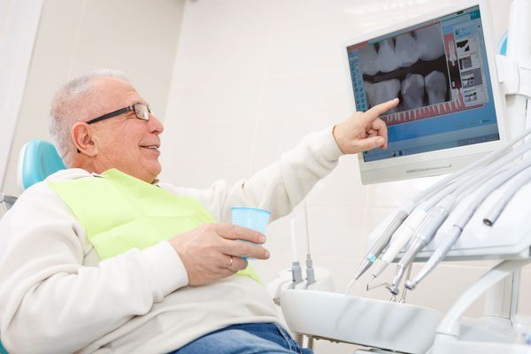 Elderly man looking at dental implant surgical guide