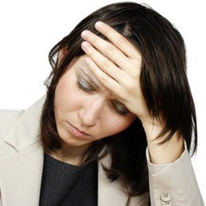 Woman touching forehead due to headache